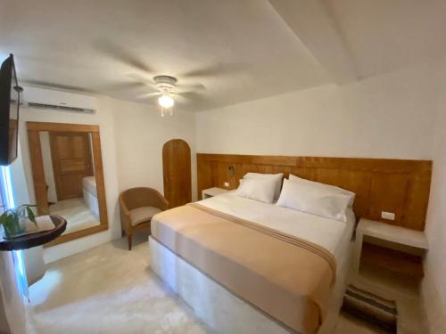 a bedroom with a large bed and a mirror at MIO Cancún Hotel Boutique in Cancún