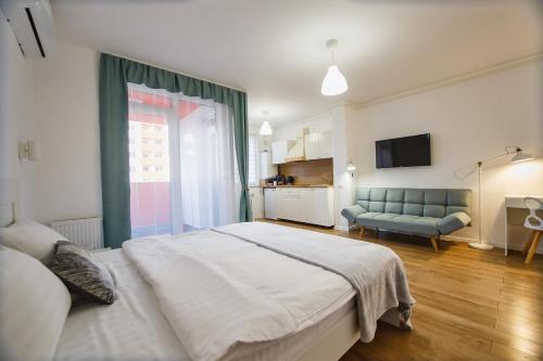 een slaapkamer met een groot bed en een blauwe bank bij Enjoy Time in Central Oradea in Oradea