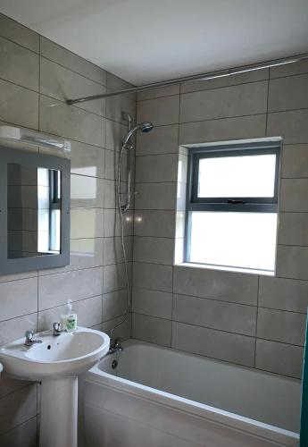 a bathroom with a sink and a bath tub and a sink at Cottage 33 Old Killarney Village Killarney V93K66X 4 King Beds Sleeps 8 Sharing in Killarney