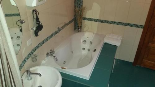 a bathroom with a tub and a sink and a toilet at Posada Tambuca in Quito