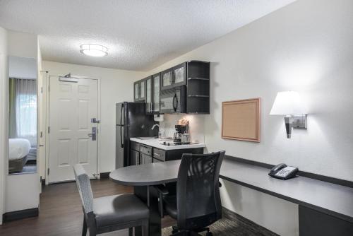a kitchen with a table and chairs in a room at Candlewood Suites Lake Mary by IHG in Lake Mary