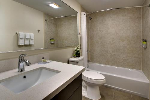 Candlewood Suites - Wichita East, an IHG Hotel في ويتشيتا: حمام مع حوض ومرحاض ودش