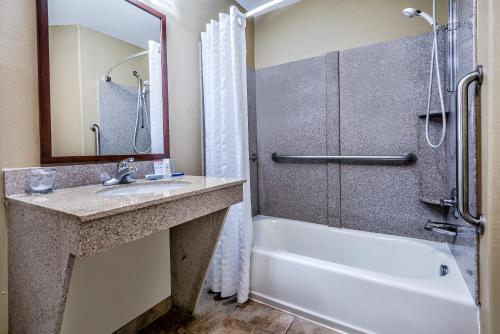 La salle de bains est pourvue d'une baignoire, d'un lavabo et d'une douche. dans l'établissement Candlewood Suites Galveston, an IHG Hotel, à Galveston