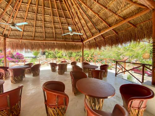 een restaurant met tafels en stoelen onder een rieten dak bij MIO Cancún Hotel Boutique in Cancun