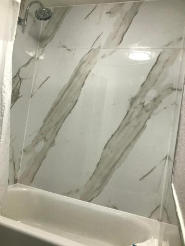 a bathroom with a white marble wall at HomeTown Inn in Clearwater