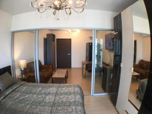 Un dormitorio con una cama y una sala de estar. en Supalai Rama9 Monthly, en Bangkok