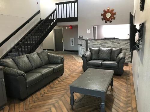 a living room with two couches and a staircase at HomeTown Inn in Clearwater