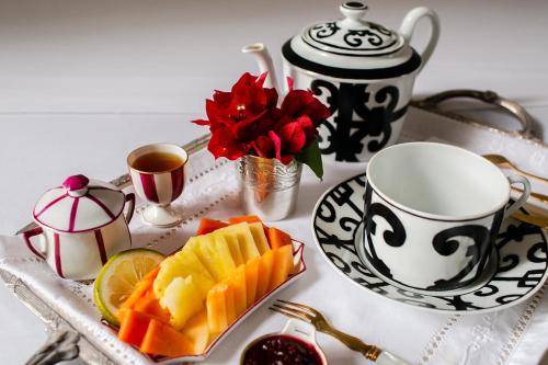 a tray with a plate of fruit and a cup of coffee at Villa Octavia in Mérida
