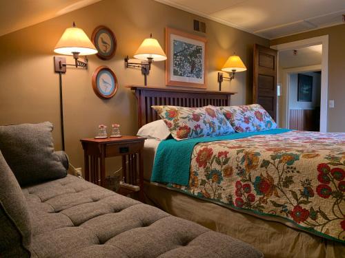 a bedroom with a bed and a couch and two lights at Kangaroo House Bed & Breakfast in Eastsound