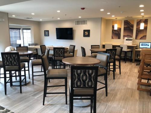 a dining room with tables and chairs in a restaurant at Staybridge Suites Detroit-Novi by IHG in Novi