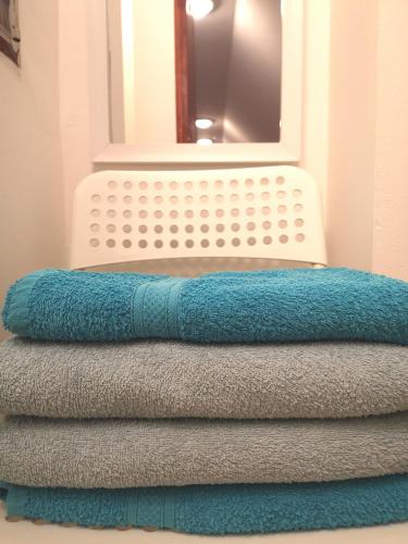 four towels stacked on top of each other in front of a mirror at HOKE lakás in Sopron