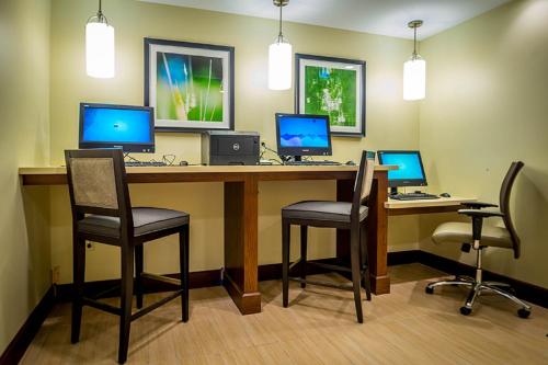 an office with a desk with three computers on it at Staybridge Suites Dearborn by IHG in Dearborn