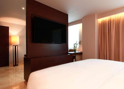 a bedroom with a large bed and a flat screen tv at Hyatt Regency Villahermosa in Villahermosa
