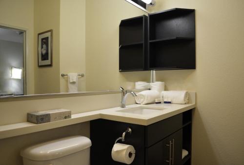 a bathroom with a sink and a toilet and a mirror at Candlewood Suites Greenville, an IHG Hotel in Greenville