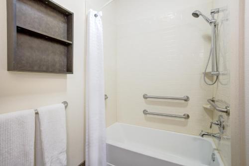 a bathroom with a white tub and a shower at Candlewood Suites Cut Off - Galliano by IHG in Galliano