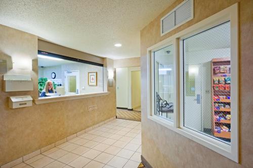 a waiting room at a pharmacy with a woman in a store at Candlewood Williamsport, an IHG Hotel in Williamsport