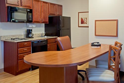 a kitchen with a wooden table and a kitchen with a dining room at Candlewood Suites Houston Westchase - Westheimer by IHG in Houston