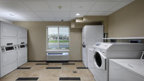 a laundry room with a washer and a window at Candlewood Suites - Newark South - University Area by IHG in Newark