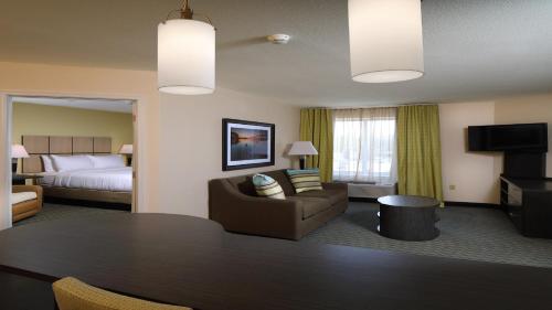 une chambre d'hôtel avec une table et un lit dans l'établissement Candlewood Suites - Newark South - University Area, an IHG Hotel, à Newark