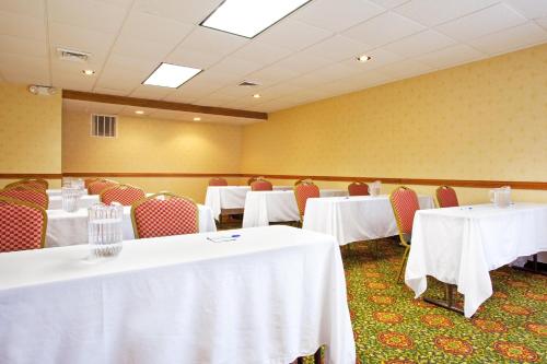 a conference room with tables and chairs with white table cloth at Candlewood Suites Grand Rapids Airport by IHG in Grand Rapids