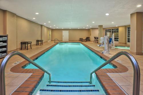 a swimming pool with stairs leading to a hotel room at Candlewood Suites Indianapolis Northeast by IHG in Indianapolis