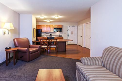 a living room with a couch and a kitchen at Candlewood Suites Pearland, an IHG Hotel in Pearland