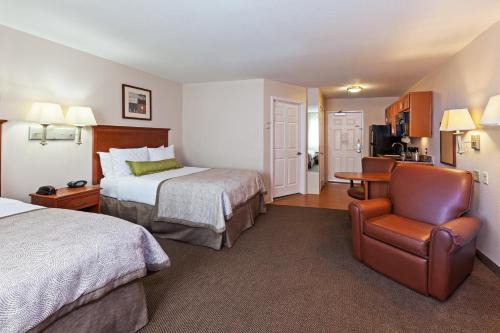a hotel room with two beds and a chair at Candlewood Suites Pearland, an IHG Hotel in Pearland