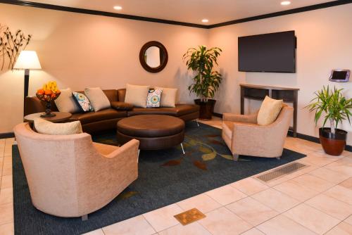 a living room with a couch and chairs and a tv at Candlewood Suites Boise-Meridian by IHG in Meridian