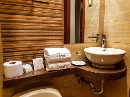 bagno con lavandino, servizi igienici e specchio di Retama Hotel a Tacna