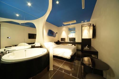 a bathroom with a tub and a bed and a bath tub at Hotel Star in Seoul