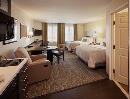 Candlewood Suites - Lake Charles South, an IHG Hotel في ليك تشارلز: غرفة فندقية بسريرين ومكتب