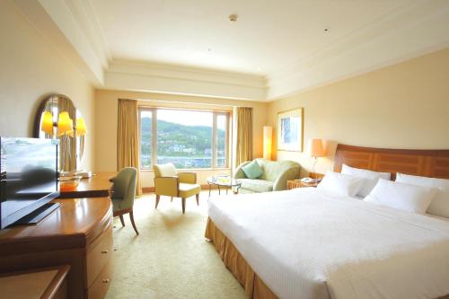 a hotel room with a large bed and a desk at Grand Park Otaru in Otaru