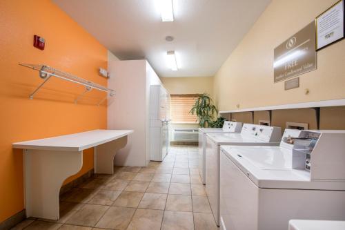a kitchen with white appliances and orange walls at Candlewood Suites Houston Medical Center by IHG in Houston