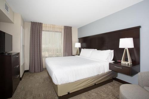 a hotel room with a bed and a television at Staybridge Suites Denver South - Highlands Ranch by IHG in Littleton