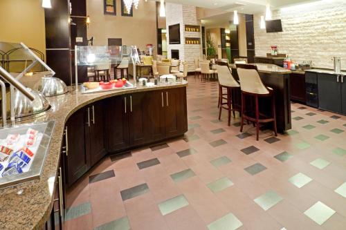 a kitchen with a counter and bar stools at Staybridge Suites DFW Airport North by IHG in Irving