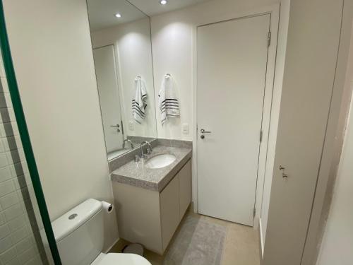 uma casa de banho com um lavatório, um WC e um espelho. em SUA CASA NA VILA MADALENA em São Paulo