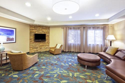 a living room with a couch and a tv at Candlewood Suites Indianapolis Airport by IHG in Indianapolis
