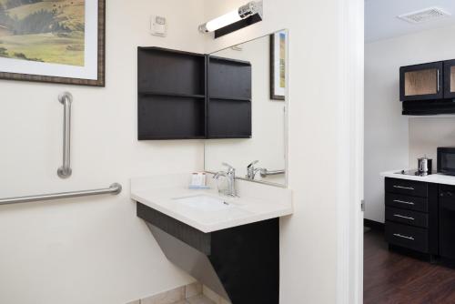 a bathroom with a sink and a mirror at Candlewood Suites Olympia - Lacey by IHG in Lacey