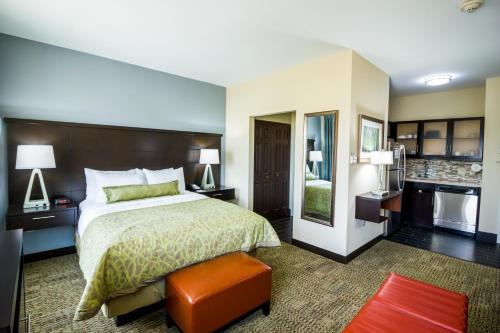 une chambre d'hôtel avec un lit et une cuisine dans l'établissement Staybridge Suites Plano - Legacy West Area, an IHG Hotel, à Frisco