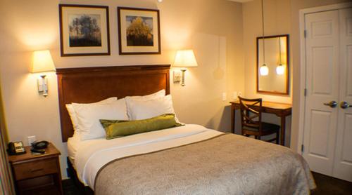 a hotel room with a bed and a desk at Candlewood Suites Jacksonville by IHG in Jacksonville