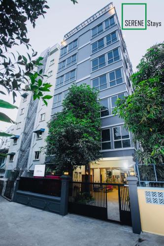 a building with a tree in front of it at SERENE Stays Hotel in Yangon