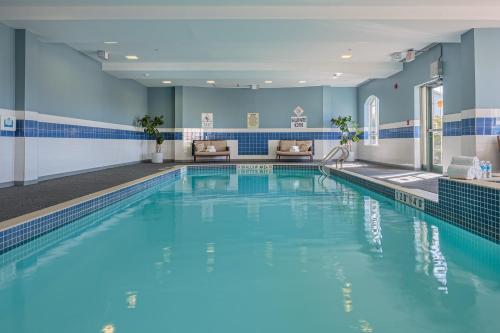 a large swimming pool with blue tiles on the walls at Holiday Inn Express & Suites - Belleville by IHG in Belleville