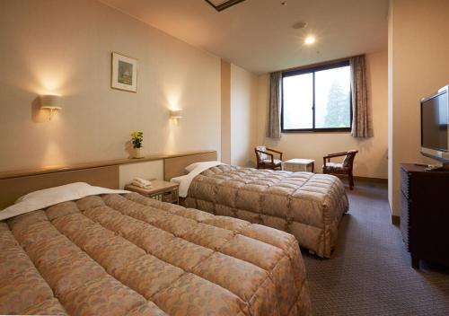 Postel nebo postele na pokoji v ubytování Kirishima Hotel