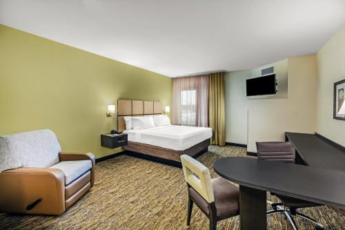a hotel room with a bed and a desk at Candlewood Suites Lenexa - Overland Park Area by IHG in Lenexa