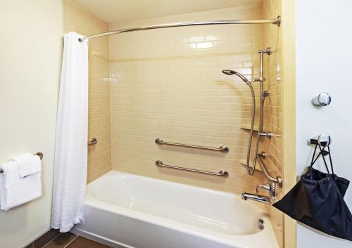 a bathroom with a white tub and a shower at Candlewood Suites Lenexa - Overland Park Area by IHG in Lenexa