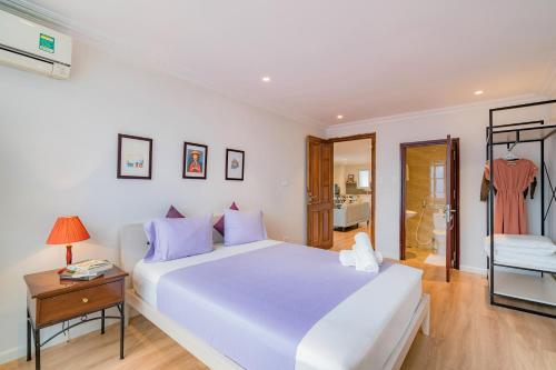 a bedroom with a large white bed and a table at WECOZY HANOI - Railway Side, The Old Quarter in Hanoi