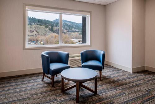 a waiting room with two chairs and a table and a window at Holiday Inn Express & Suites Kelowna - East by IHG in Kelowna