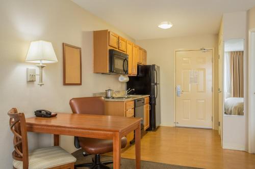 a small kitchen with a table and a refrigerator at Candlewood Suites Nogales by IHG in Nogales