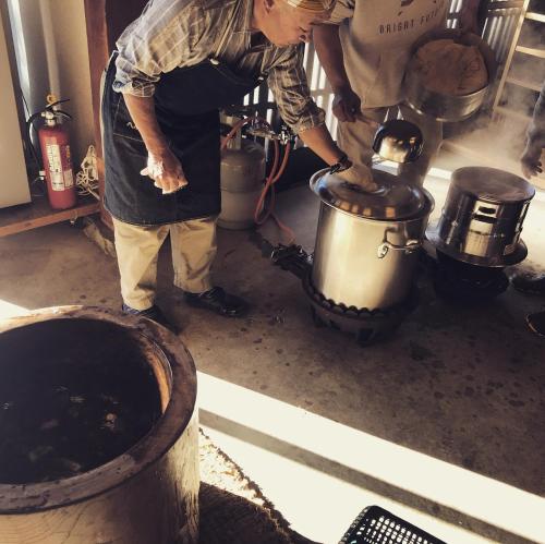 a man is pouring something into a pot in a kitchen at Fukui Furusato Chaya Kine to Usu in Fukui