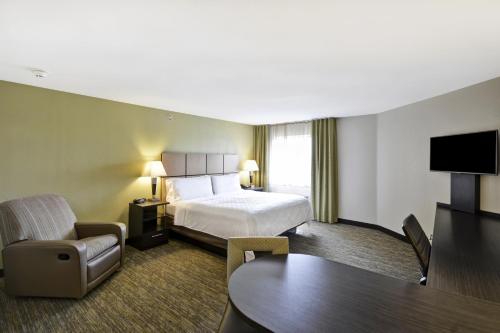 una grande camera d'albergo con un letto e una sedia di Candlewood Suites Smyrna - Nashville by IHG a Smyrna